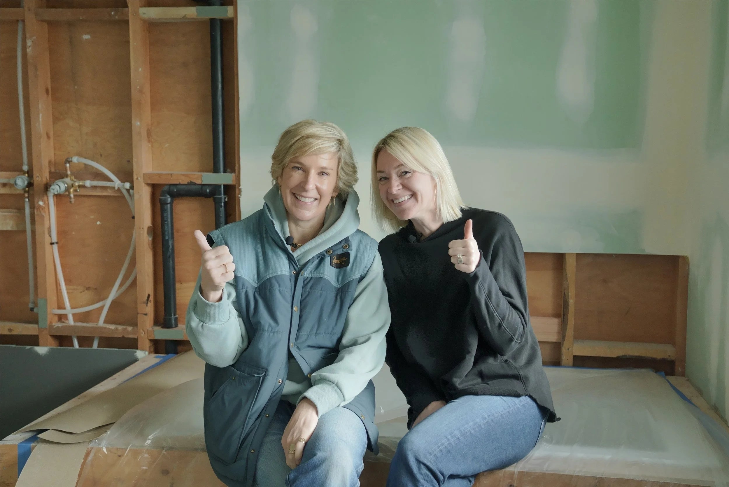 Teal and Scott giving thumbs up at a renovation site